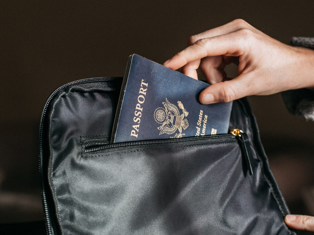 Leather passport being placed into a black bag demonstrating concerns over the Kids Online Safety Act and privacy of identity